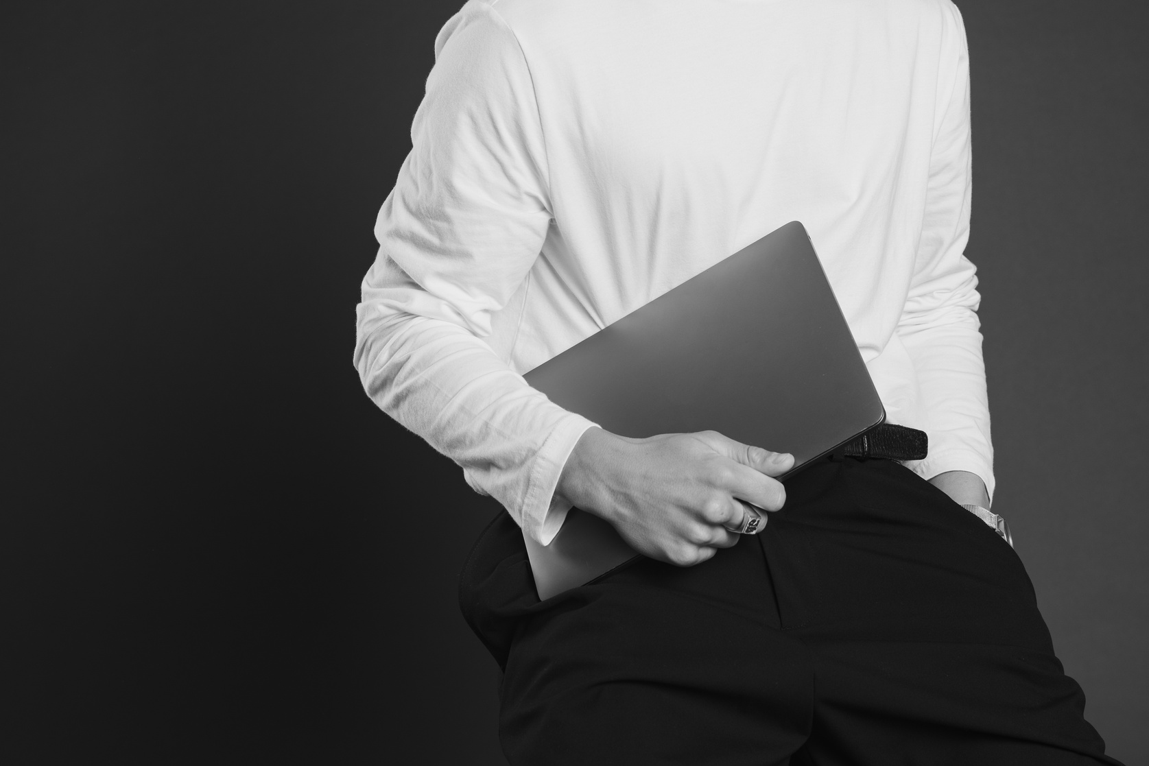 Man Carrying a Laptop on Black Background